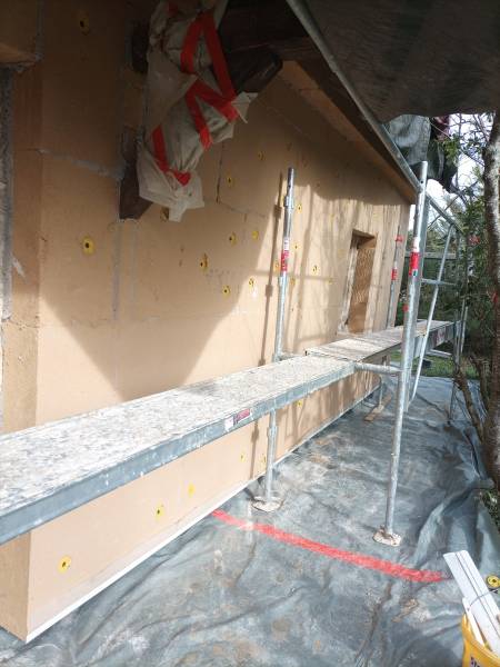 Pose de panneaux isolants en fibre de bois et fixation avec des chevilles, chantier d'ITE  dans le Gers par Gayral Isolation