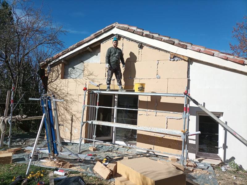 Pose de panneaux isolants en fibre de bois, colés et chevillés, chantier ITE par Gayral Isolation- Gers e
